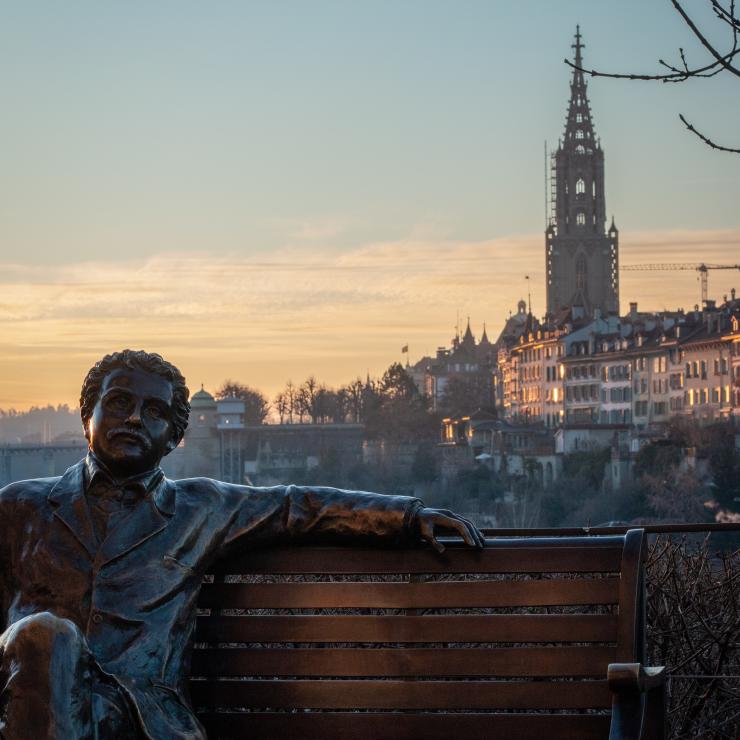 Statue of Albert Einstein on a bench, Bern's old town in the background