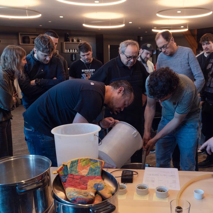 Menschengruppe beim Bierkochen