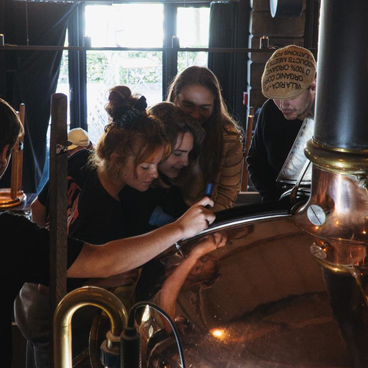 A group of people looking into the brewing pan